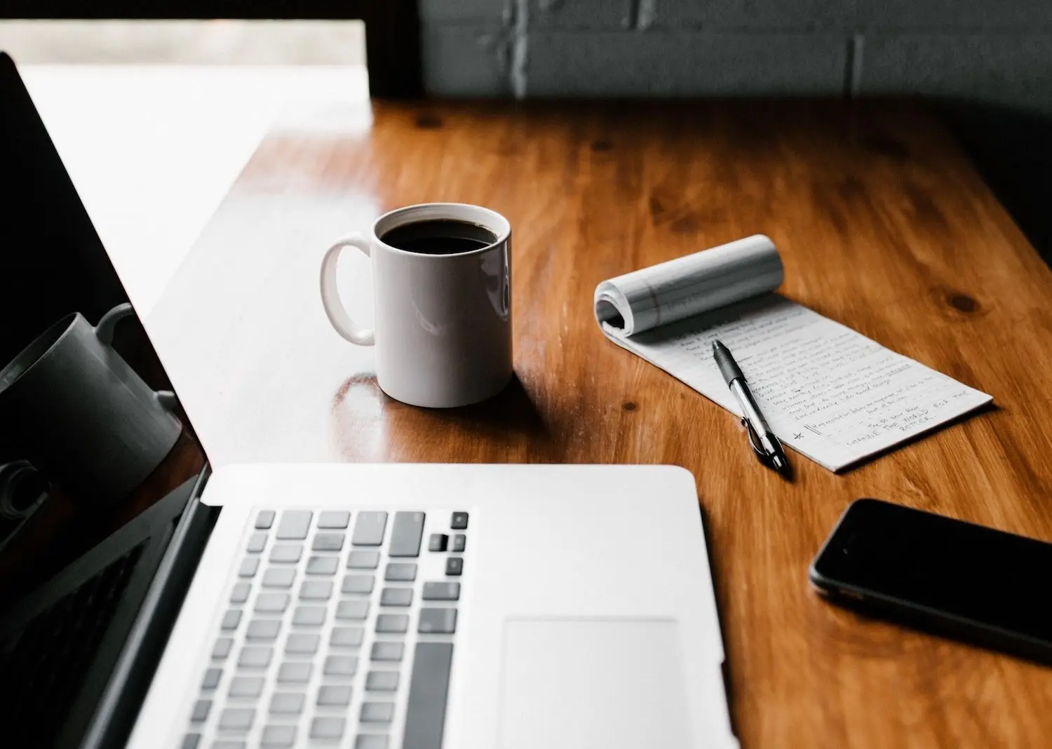 Laptop, Notizblock und Kaffeetasse auf einem Schreibtisch Laptop, Notizblock und Kaffeetasse auf einem Schreibtisch